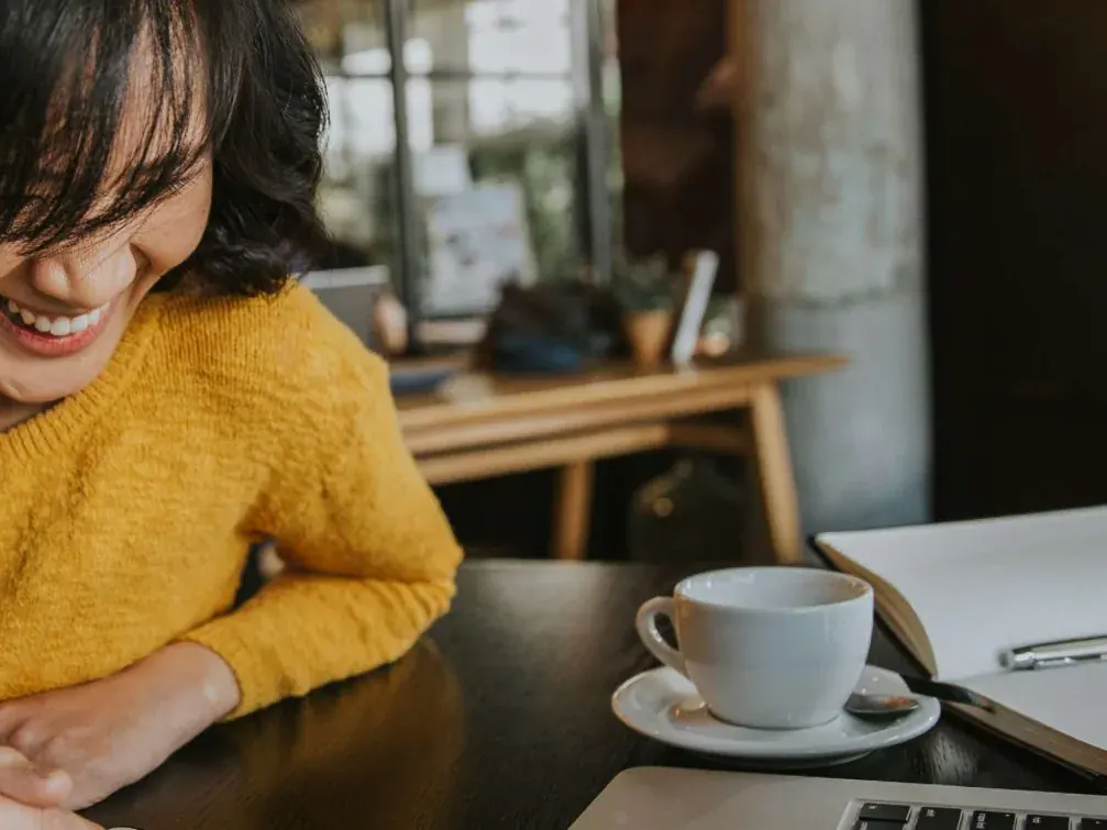 Conseillère bancaire souriante devant un café